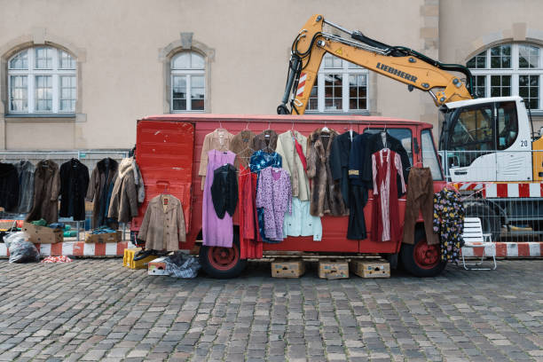 Berlin, Germany - July 27, 2019: Street flea market with old second-hand clothes with hangers in a red van