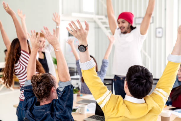istock Young multiethnic diverse creative asian group huddle and high five hands together in office workshop with success or empower expression in teamwork. Young happy asian marketing team bonding concept. 1178077463
