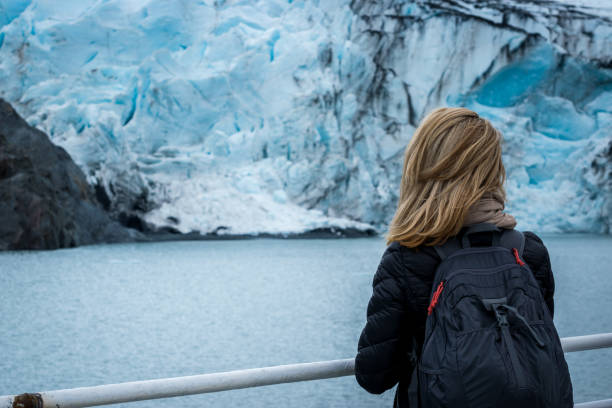 istock Woman looking at mountain range and glacier. 1178077520