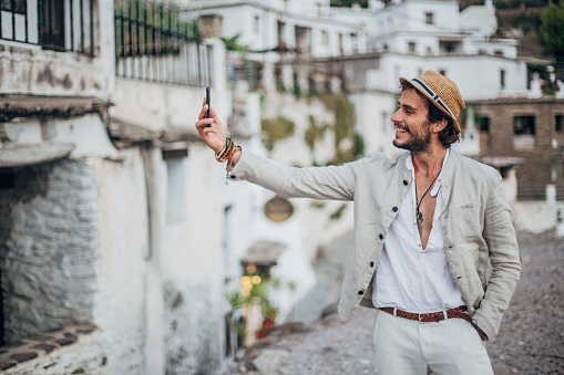 Handsome hipster man taking a selfie in some Spanish village