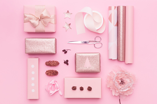 Gift wrapping. Pink nordic christmas gifts isolated on pastel pink background. Wrapped xmas boxes layout.