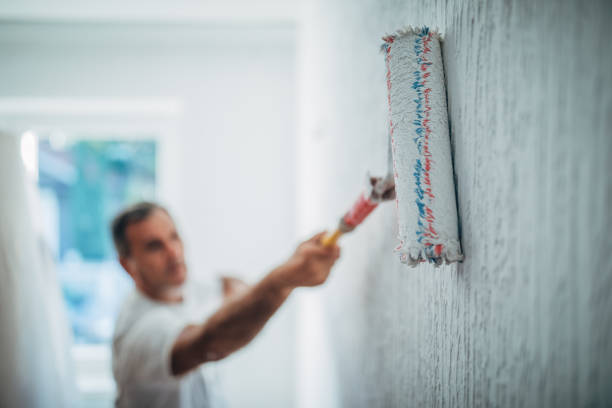 istock One man painting home with paint roller 1178082673