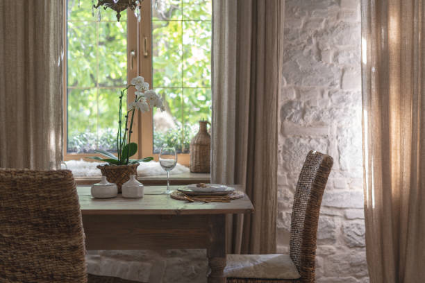 istock Table setting with wine glass, plates, elegant tableware and white orchid flower on wooden table. Cozy house with vintage interior style and home decor 1178084831