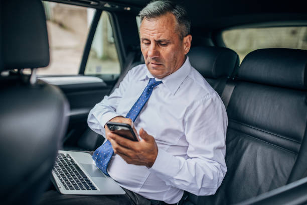 istock Man working on the laptop in the car and texting 1178085658