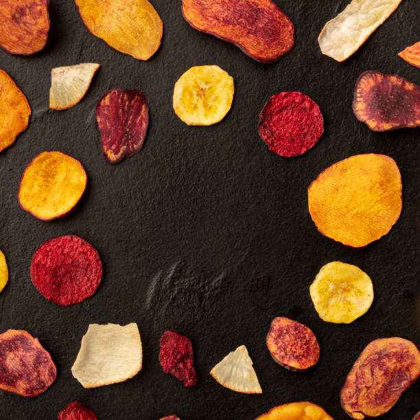 istock Dry fruit and vegetable chips on a black background, forming a frame for copy space, overhead square shot 1178087820