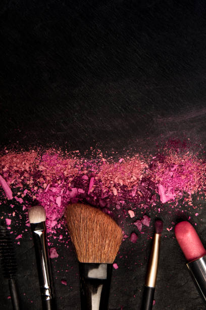 istock Make-up brushes and lipstick with crushed cosmetics, shot from the top on a dark background with a place for text, a beauty design template for a makeup banner 1178088086