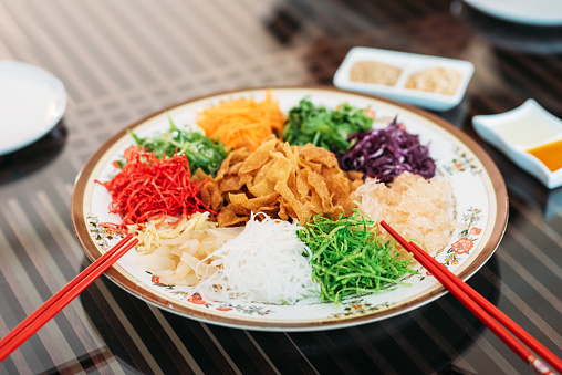 Image of Serving of Yee Sang or YuSheng with raw salmon fillet traditional Chinese New Year prosperity delicacies.