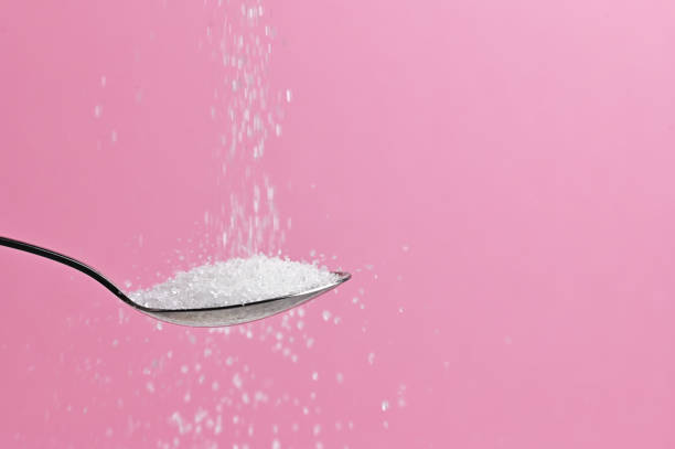 white sugar pouring from a spoon - sugar spoon salt teaspoon imagens e fotografias de stock