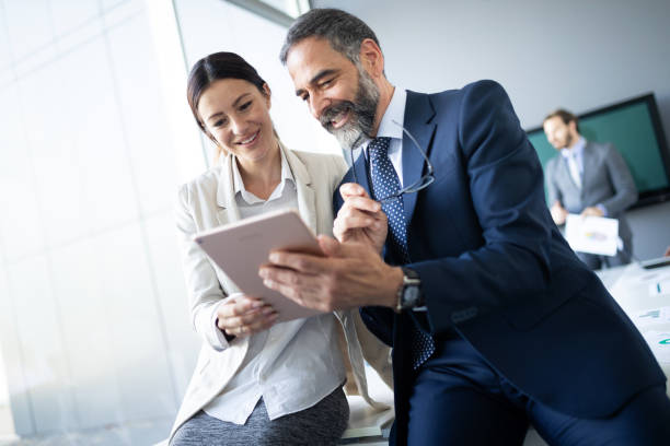 istock Happy business colleagues in modern office using tablet 1178092505