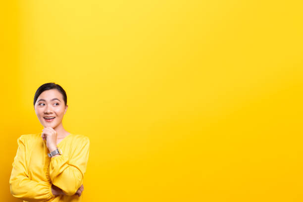 istock Happy woman thinking and standing isolated over yellow background 1178094130