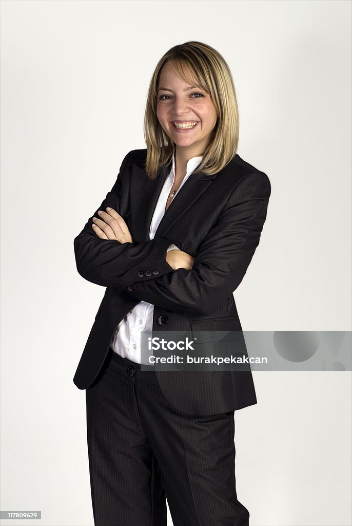 Donna d'affari in piedi con le braccia incrociate contro sfondo bianco, sorridente, Turchia - Foto stock royalty-free di 25-29 anni