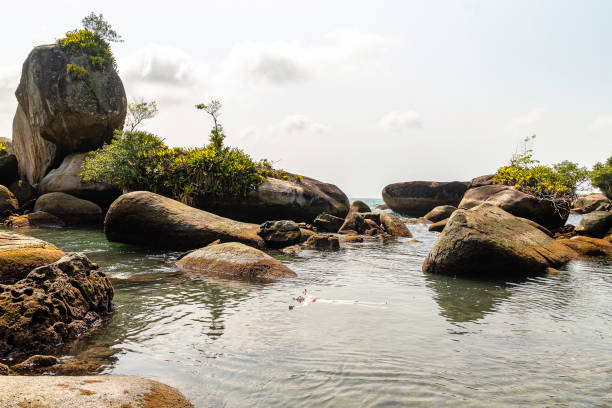 Beautiful model floating over natural pool, Trindade, Rio de Janeiro, Brazil.