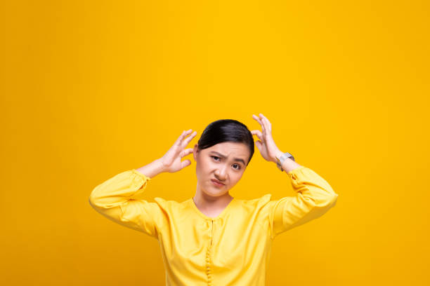 istock Woman scratching her head isolated over yellow background 1178100945