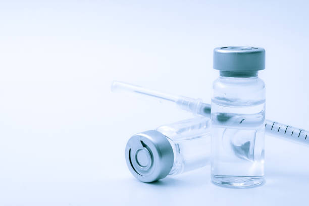 vaccines, botulin toxin and insulin ampules concept theme with glass vials with clear liquid next to a syringe and a hypodermic needle isolated on white background with copy space - insulin vial diabetes syringe imagens e fotografias de stock