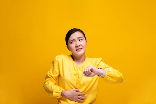 istock Woman has stomach ache isolated over yellow background 1178101734