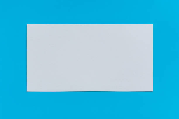 istock Blank white sheet of paper on a blue background, top view. Mock up 1178103086