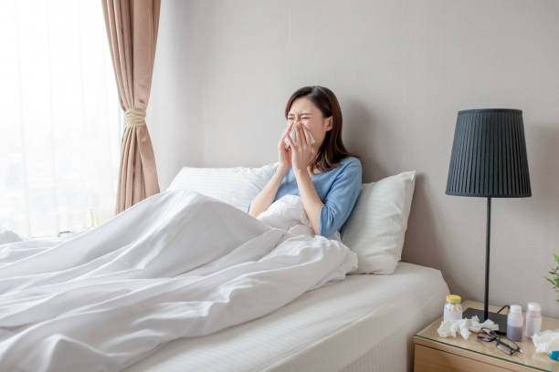 woman has running nose asian woman sick and sneeze with tissue paper in the bedroom bed of hay stock pictures, royalty-free photos & images