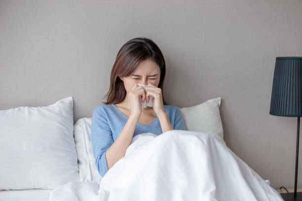 woman has running nose asian woman sick and sneeze with tissue paper in the bedroom bed of hay stock pictures, royalty-free photos & images