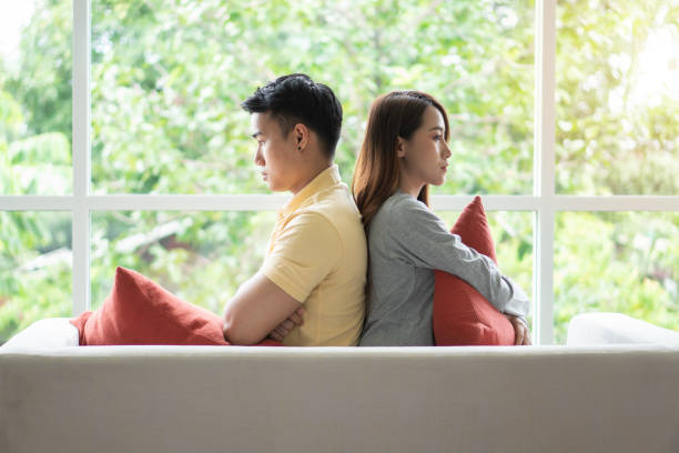 istock Unhappy Couple sitting behind each other on the couch and avoid talking or looking at each other, Cause of relationship problems and having misunderstanding or disagreement. Family problems concept 1178105531