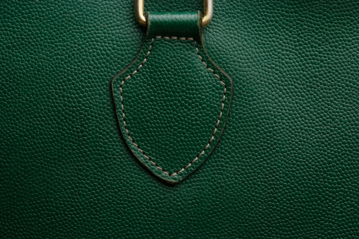 Close-up of a green bag leather texture with slight vignette.