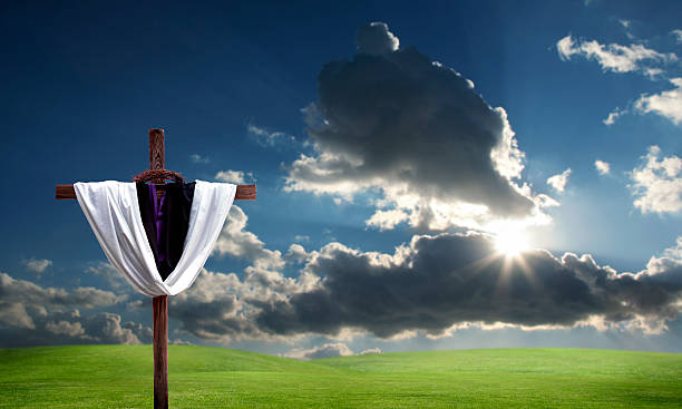 istock cross on green landscape and sun 117810690