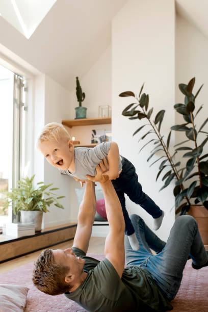 istock Father carrying blond cheerful son at home 1178112280