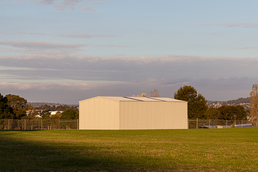 White storage shed in open field of a business park.