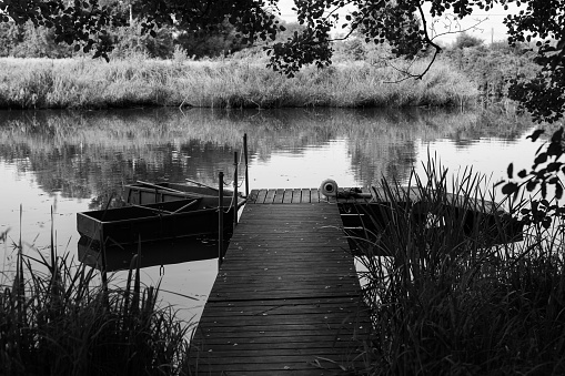 Wooden pier, boats. No people. Krakow in Poland. Black and white.