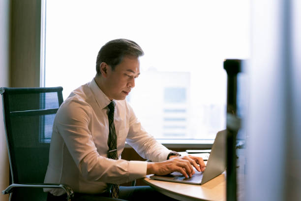 istock Serious businessman using laptop at desk in office 1178116497