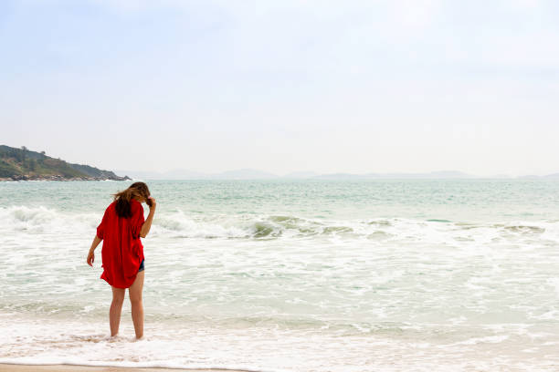 istock Model on a deserted beach walking into the sea 1178119266