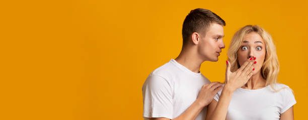istock Young guy sharing secret with his shocked girlfriend 1178121465