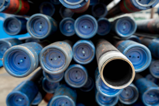 Stack of oil production pipe (specific name called Tubing) that store at material yard. Normally pipe threaded will cover by protector. Selected focus on threaded each. Close up object.