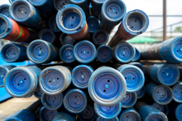 Stack of oil production pipe (specific name called Tubing) that store at material yard. Normally pipe threaded will cover by protector. Selected focus on threaded each. Close up object.