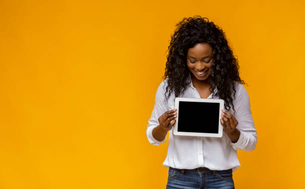 istock Happy afro girl demonstrating blank digital tablet screen 1178124610