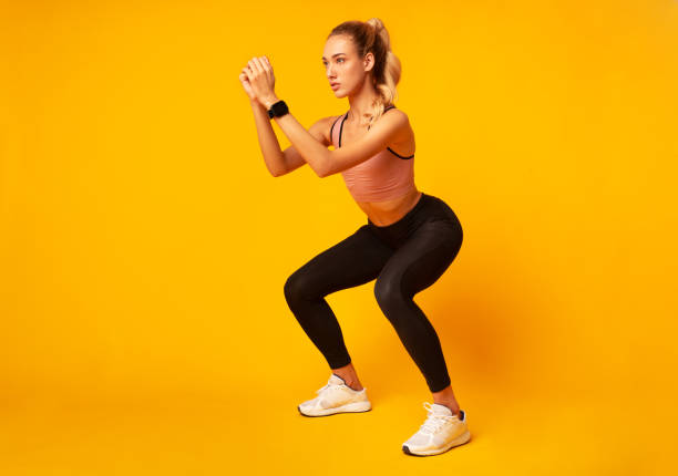 istock Young Woman Doing Deep Squat Exercise Over Yellow Background 1178125413