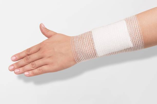 bandage en el brazo humano herido - gauze fotografías e imágenes de stock