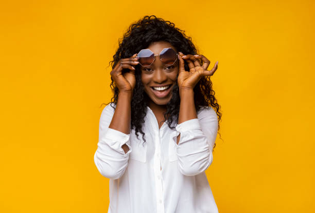 istock Young afro woman playing with her sunglasses 1178129309