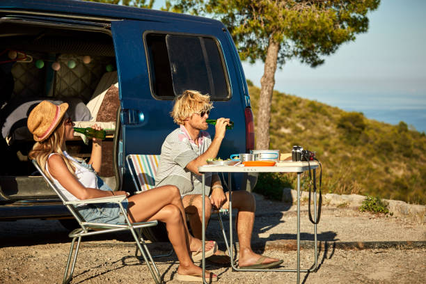 istock Mid adult couple drinking beer against mini van 1178129806
