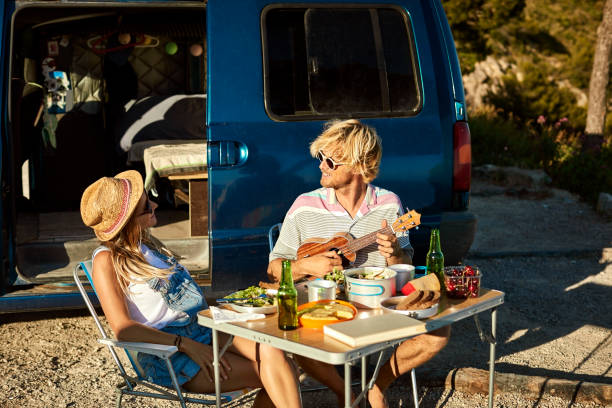 istock Man playing guitar for girlfriend against mini van 1178129834