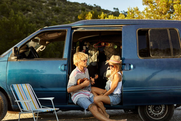 istock Man playing guitar for girlfriend in van doorway 1178129889