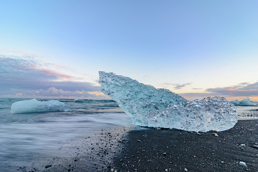 Ice shape washed up on the shore of the volcanic beach near the Jokulsalon glacier lagoon in Iceland