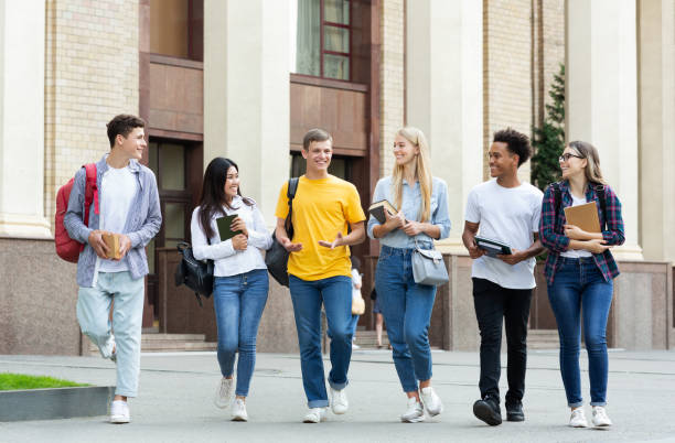 istock University life. Classmates walking outside and talking 1178130233