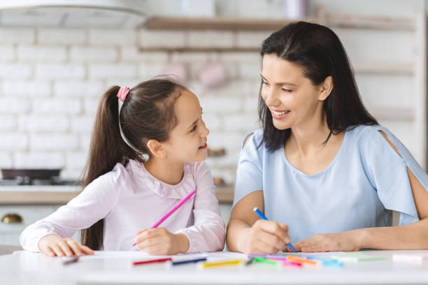 istock Cute daughter and young mother drawing together in kitchen 1178131040