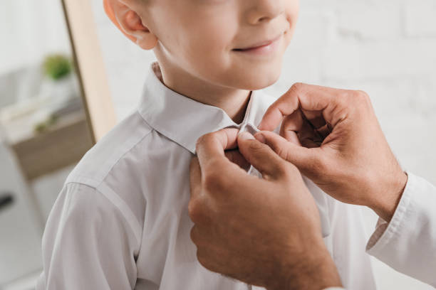istock partial view of dad helping son to get dressed 1178132739