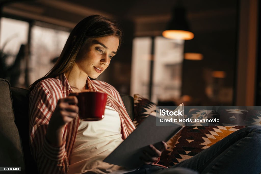 Young woman reading book Women, Reading, One Woman Only, Females, Coffee, Tea Night Stock Photo