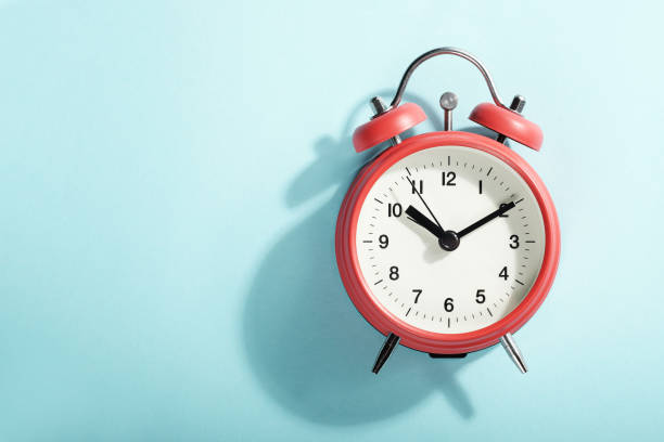 istock Red alarm clock with shadow lying on blue background. View from above. 1178136566