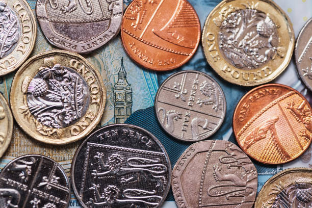 Great Britain Pound (GBP) coins and Big Ben from a 5 GBP banknote Diverse Great Britain Pound (GBP) coins. The Big Ben design in the background comes from a 5 GBP banknote. one pound coin photos stock pictures, royalty-free photos & images