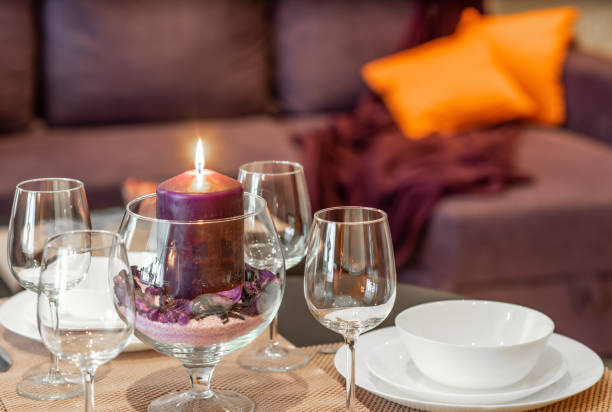 Blur background. Wine glasses. White plates. Burning candle.