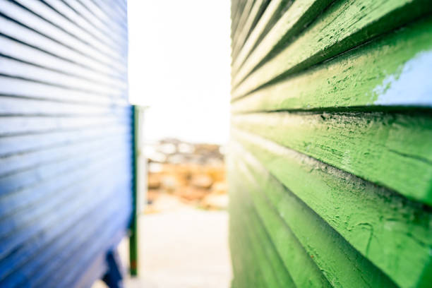 This is a close up photograph of the exterior wall of a green painted wooden hut on St. James Beach in Cape Town, South Africa.