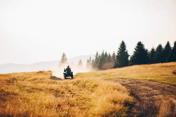 Couple riding on a quad-bike together on a mountain peak somewhere in serbia